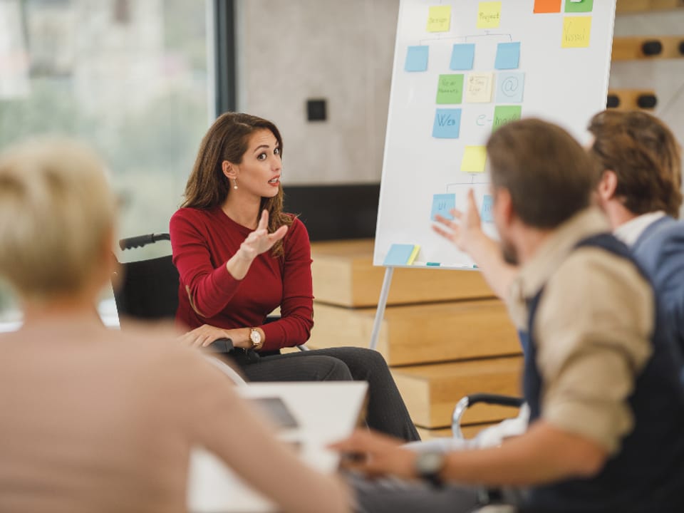 Colleagues planning at a whiteboard covered in sticky notes