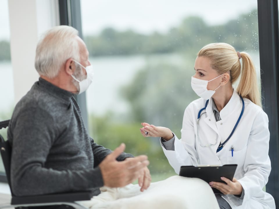 A clinician reviewing notes with a patient during a consultation